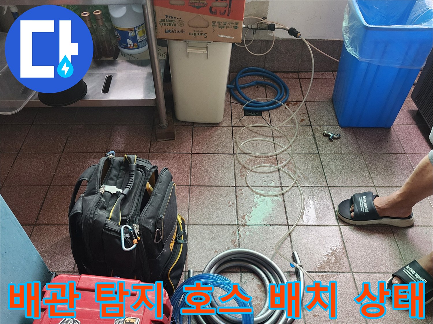 바닥에 꼬여 있는 파란색과 회색의 기능성 배관 호스들
