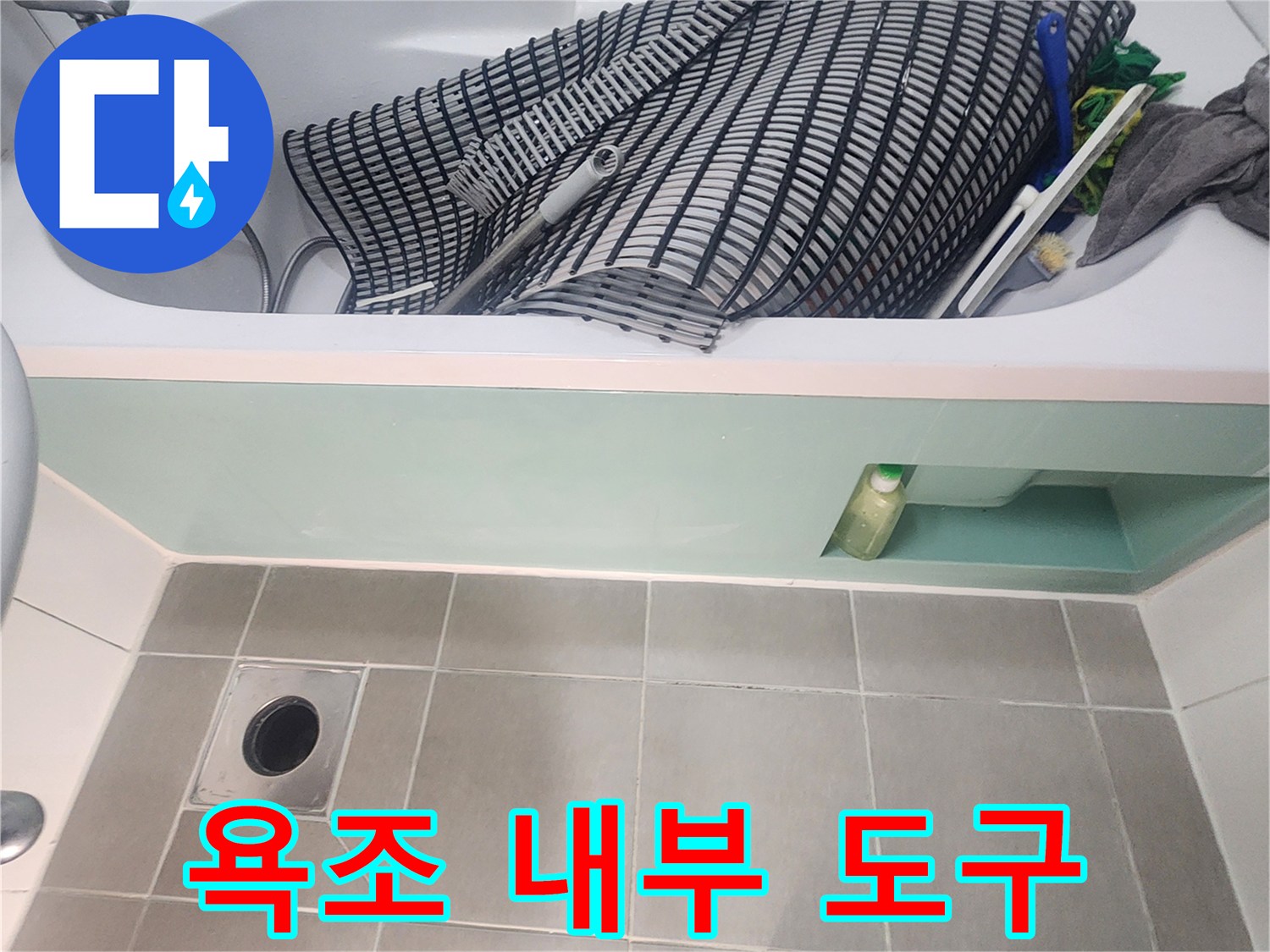 욕조 안에 놓여 있는 작업용 도구와 바닥 배수구
