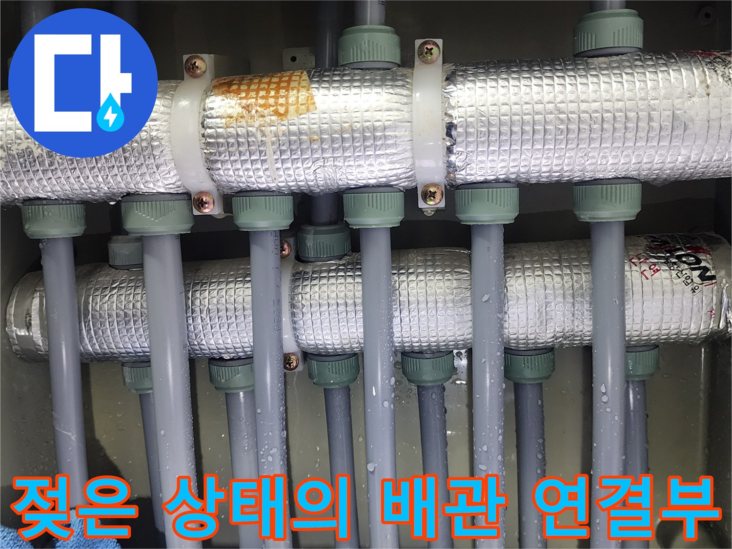 물기가 맺혀 있는 은색 배관의 결합 지점