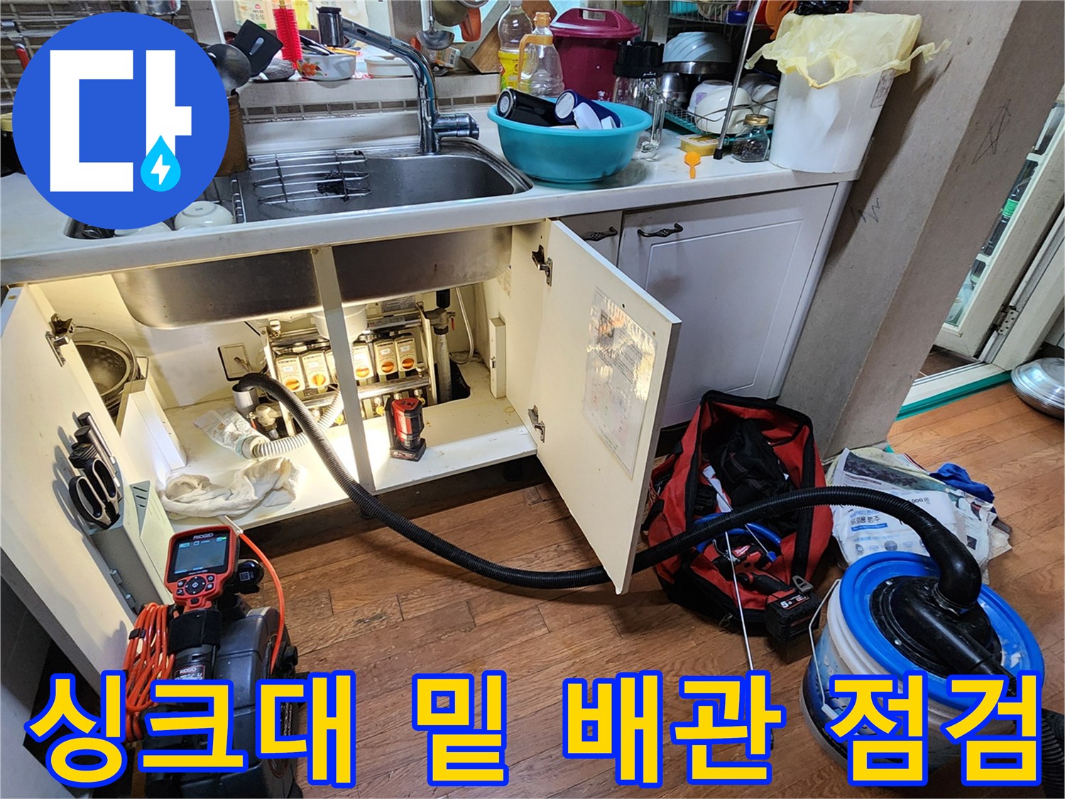 싱크대 하부장 내부의 배수 밸브와 검사용 측정기