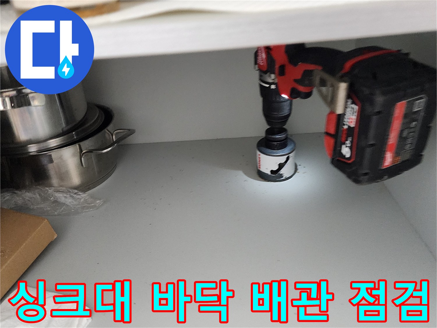드릴 장비로 싱크대 하단 구멍 확인 작업