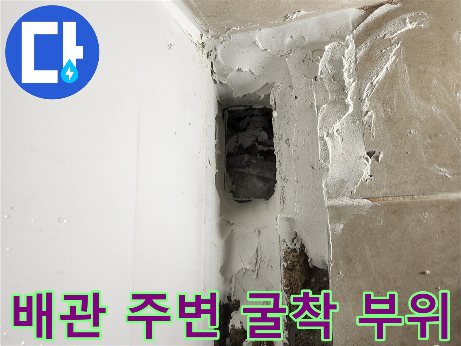 욕조 하단 배관 인근의 파손된 타일면