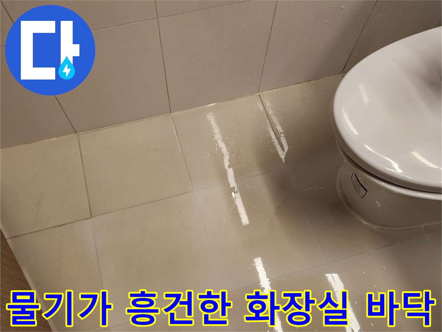 변기 옆 타일 표면에 물이 고여 있는 사진