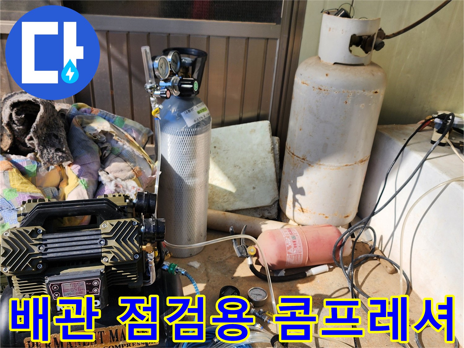 현장에서 사용 중인 공기 압축기와 가스 탐지용 호스 뭉치