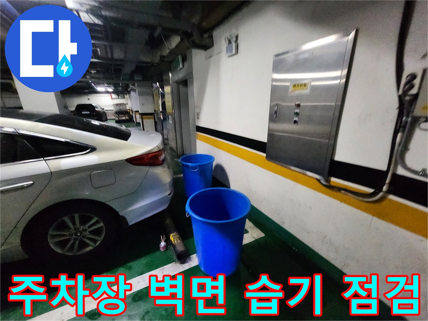 흰색 차량 옆 주차장 바닥에 놓인 파란 양동이
