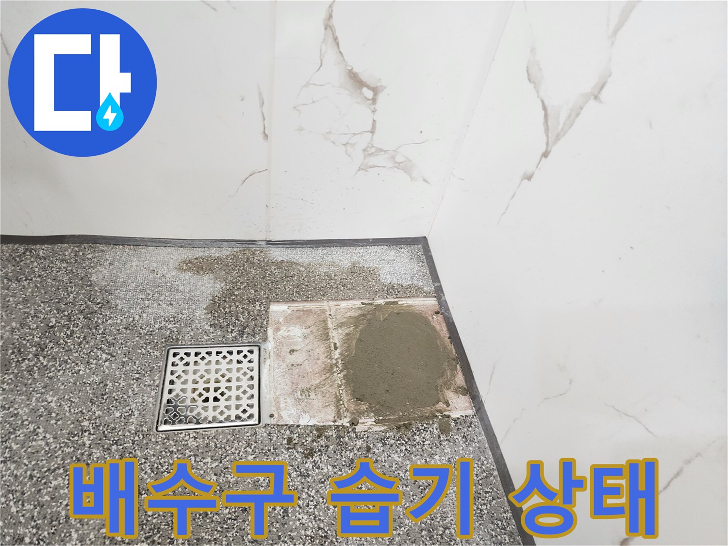 물기가 번진 화장실 배수구와 타일 바닥면