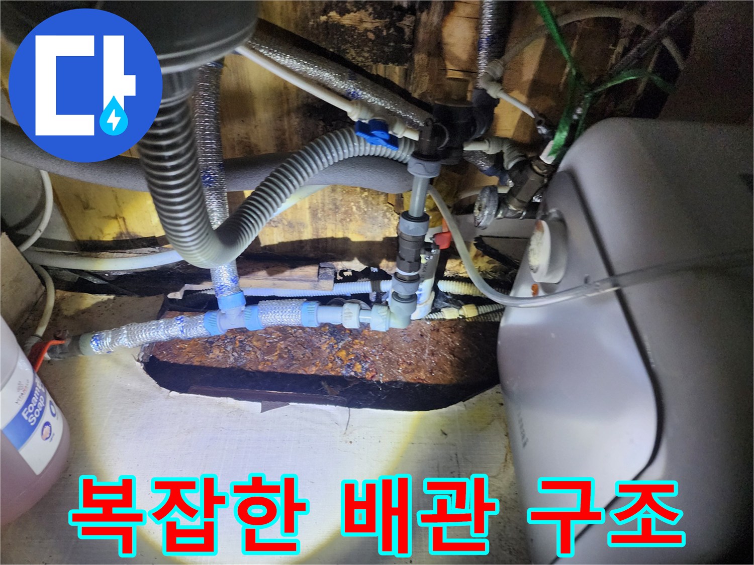 온수기와 연결된 복잡한 급수 및 배수 호스 라인