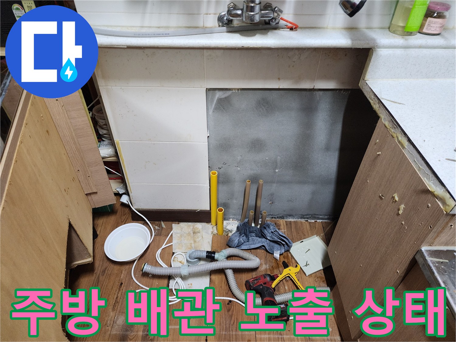 싱크대 하단부의 배관 노출 및 바닥재 젖음 현상 사진
