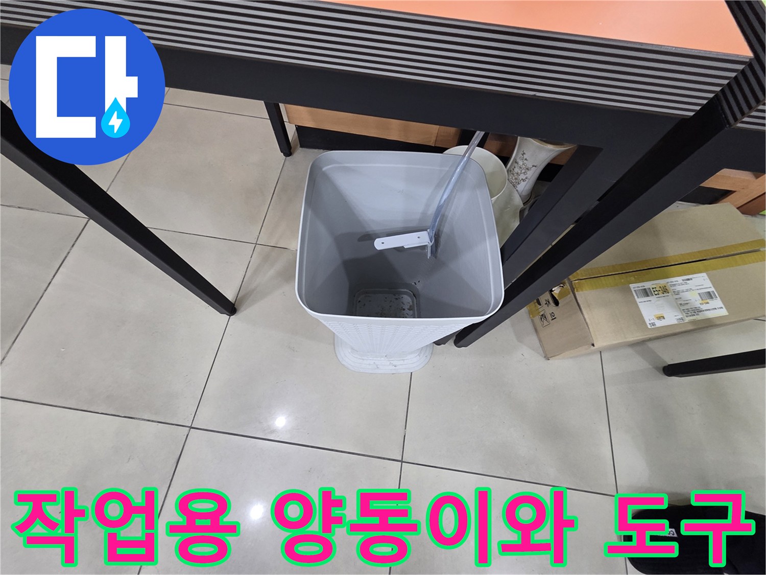 현장 바닥에 놓인 작업용 흰색 양동이와 장비
