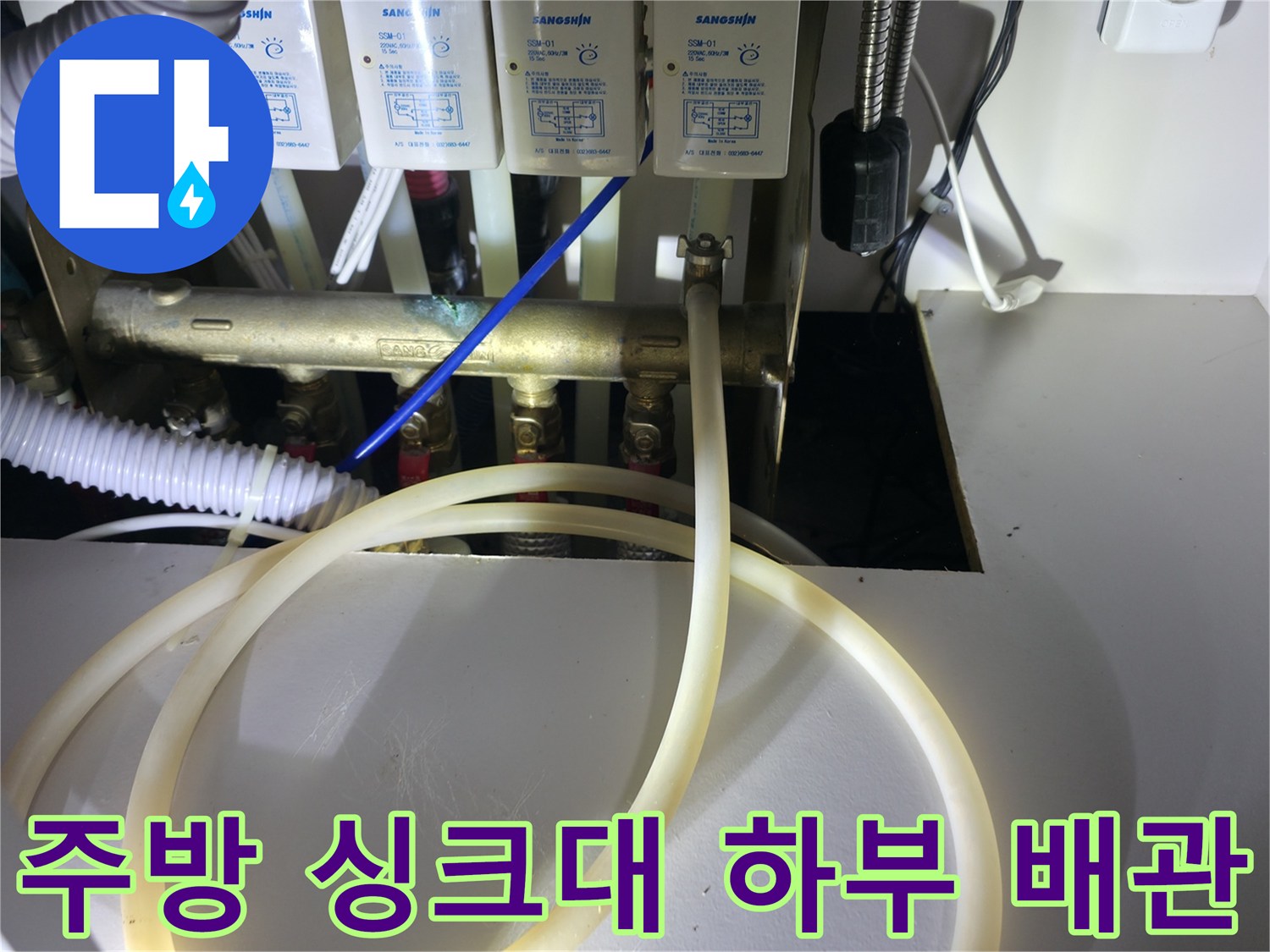 싱크대 아래 분배기 밸브 및 연결된 호스들의 모습