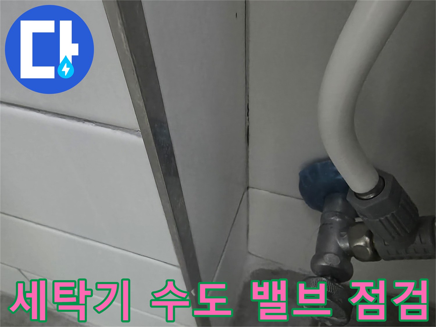 수도 밸브 연결부와 하단 타일 벽면
