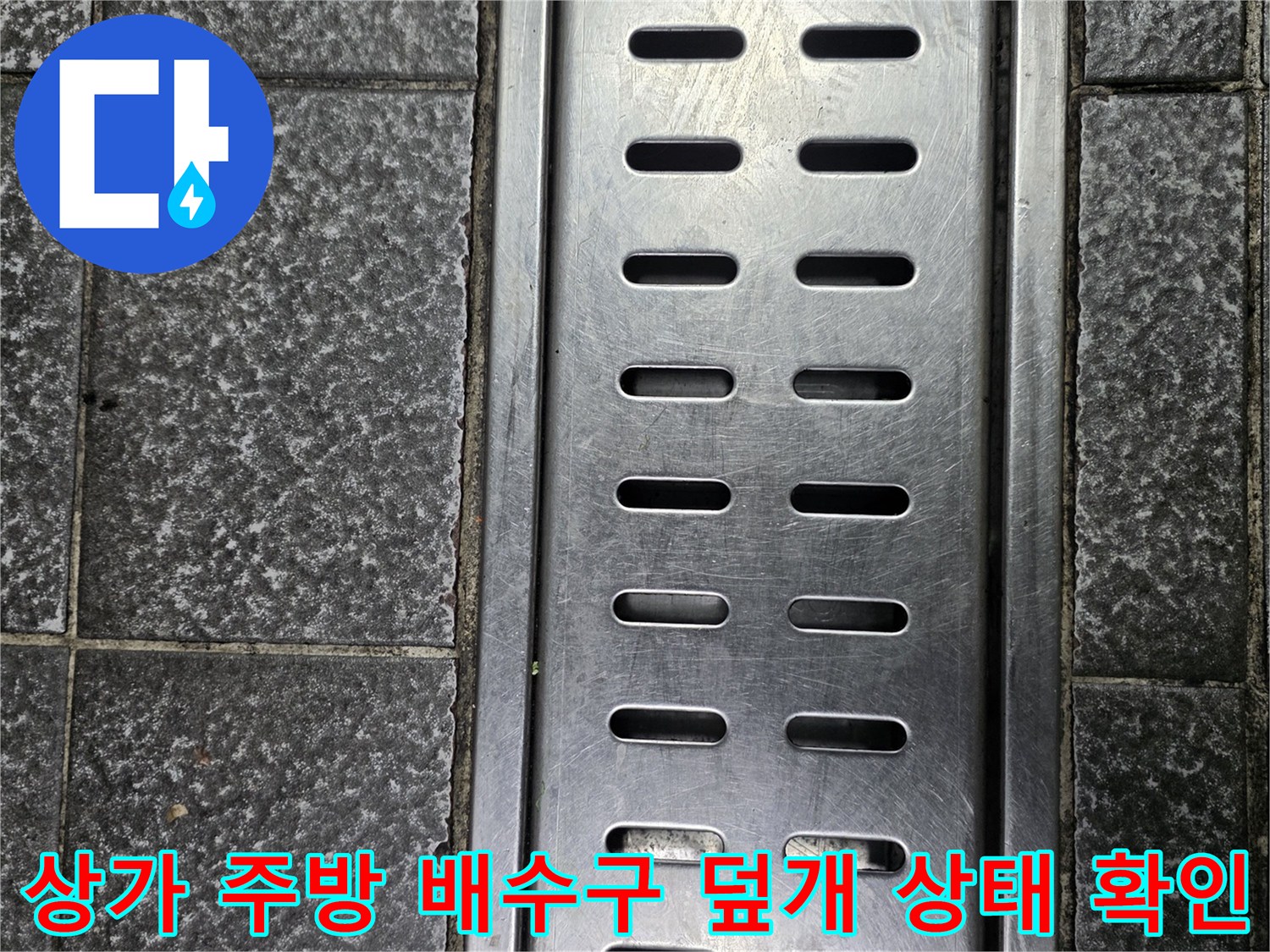 금속 재질의 배수구 커버와 주변 타일 바닥