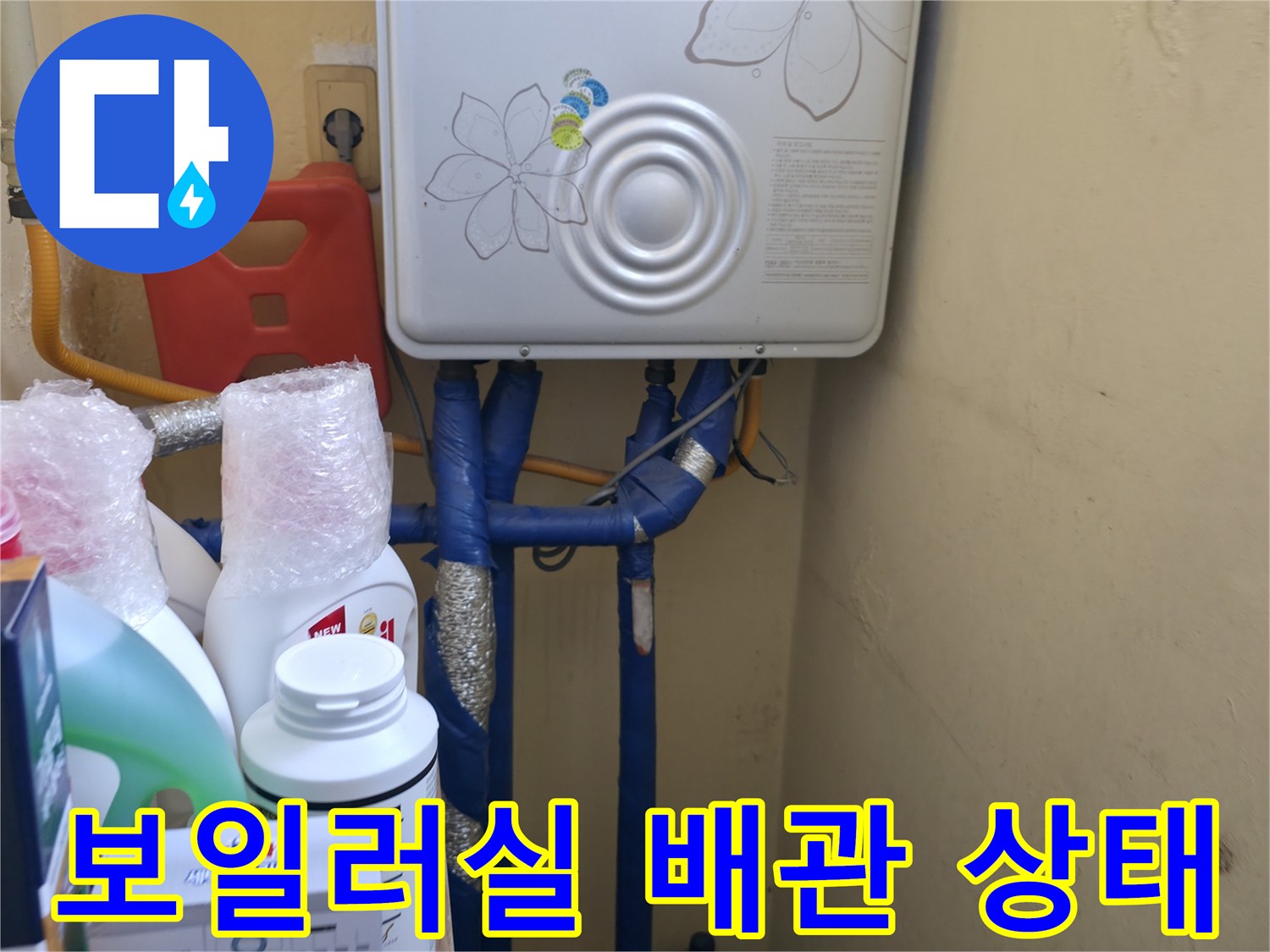 보일러 하단에 연결된 파란색 및 노란색 배관의 모습입니다.