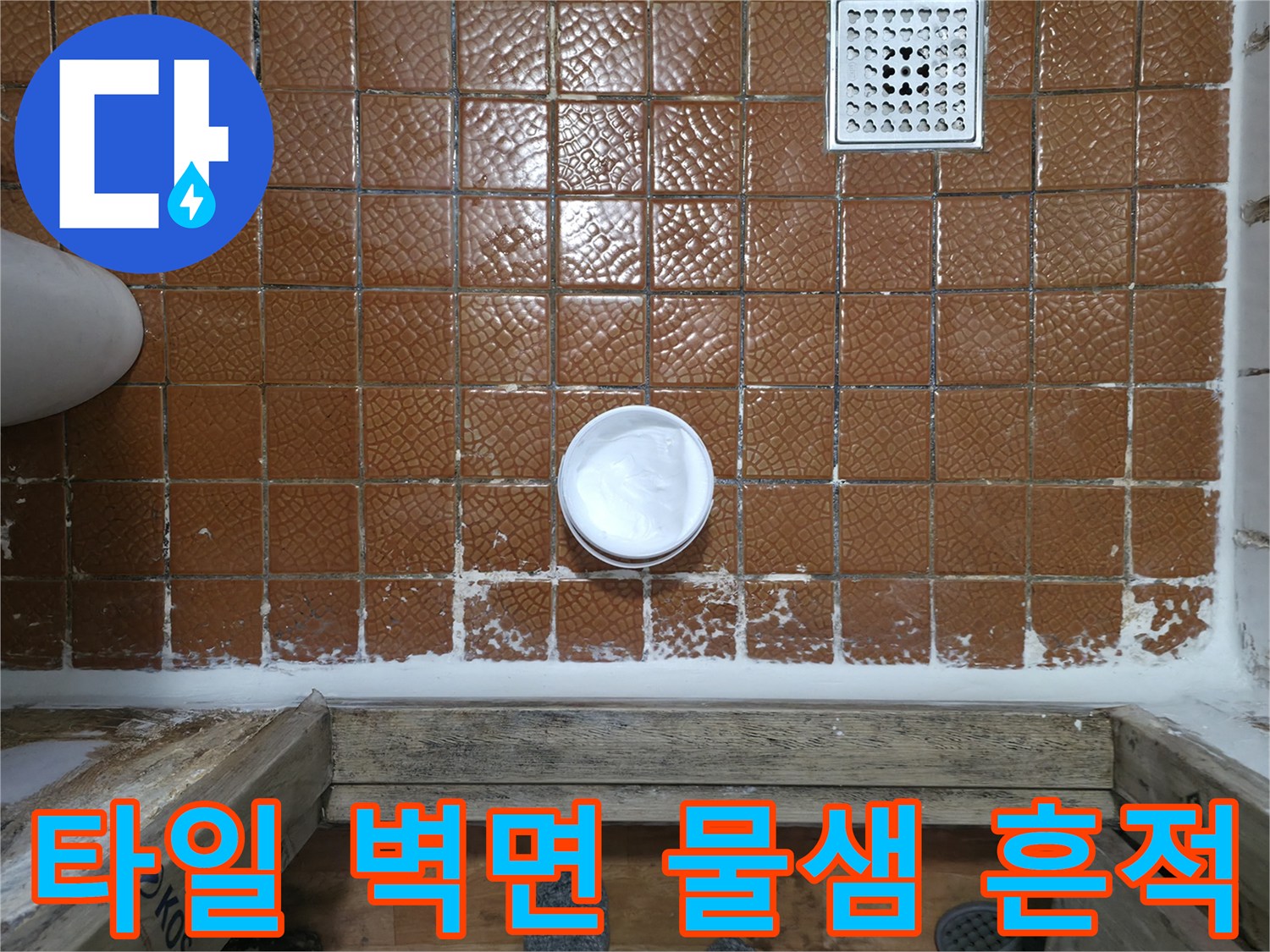 갈색 타일 사이로 보이는 습한 상태의 배수구