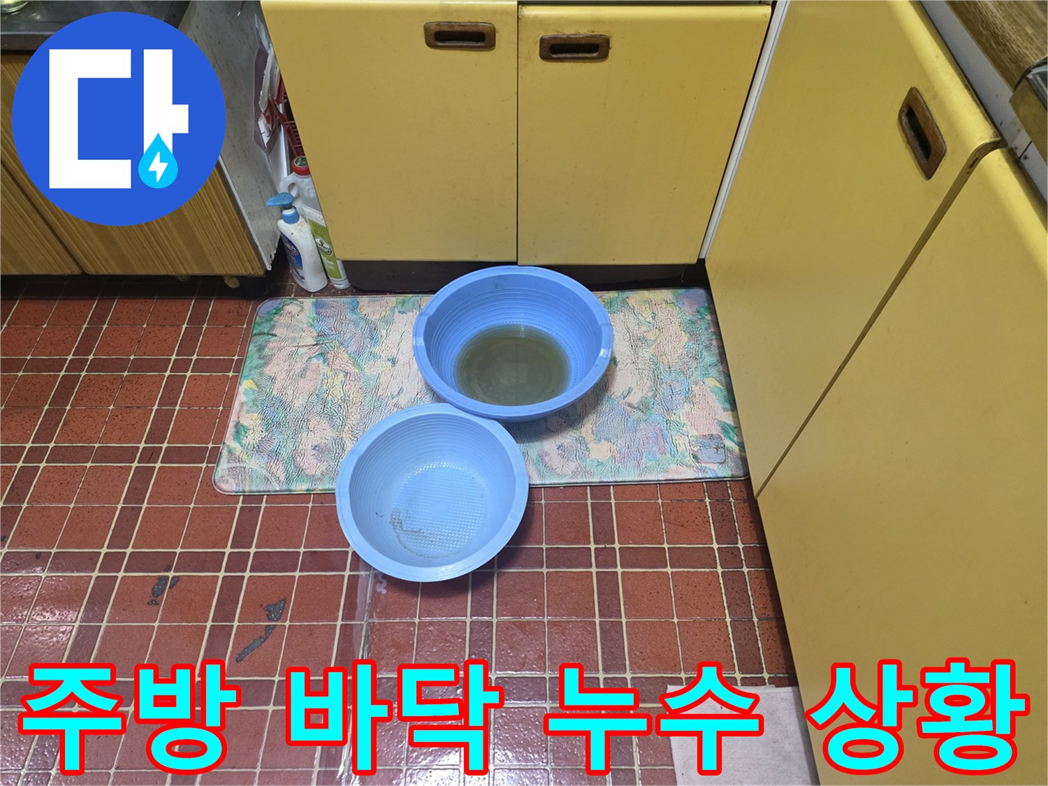 싱크대 하부장 앞-바닥 타일에 고인 물과 대야