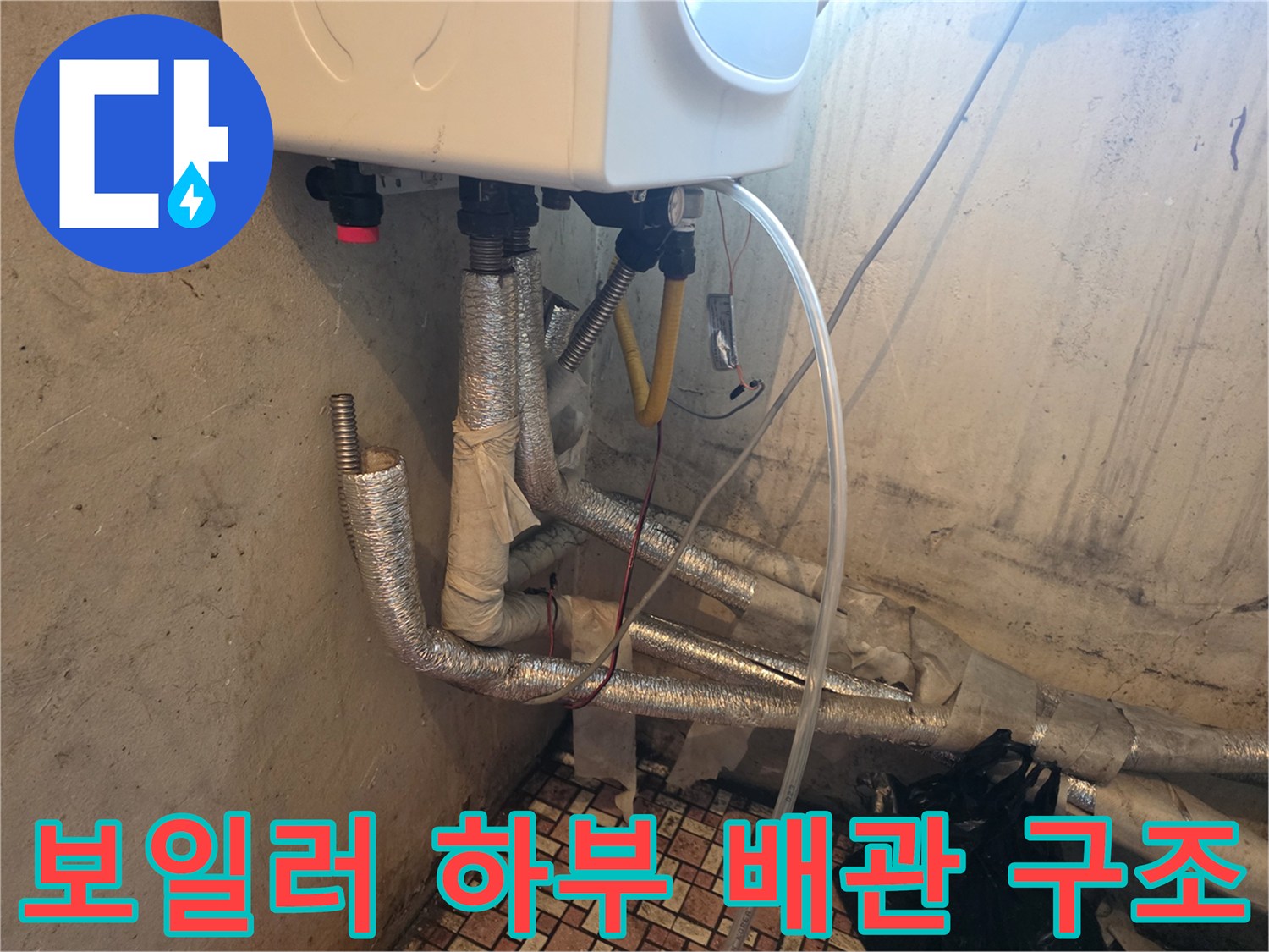 보일러 아래 연결된 은색 보온재 배관 모습