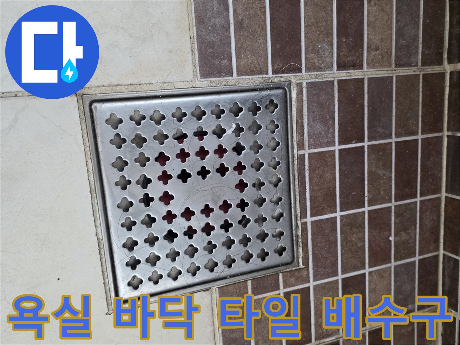 갈색-타일-배열과-금속제-배수구-덮개