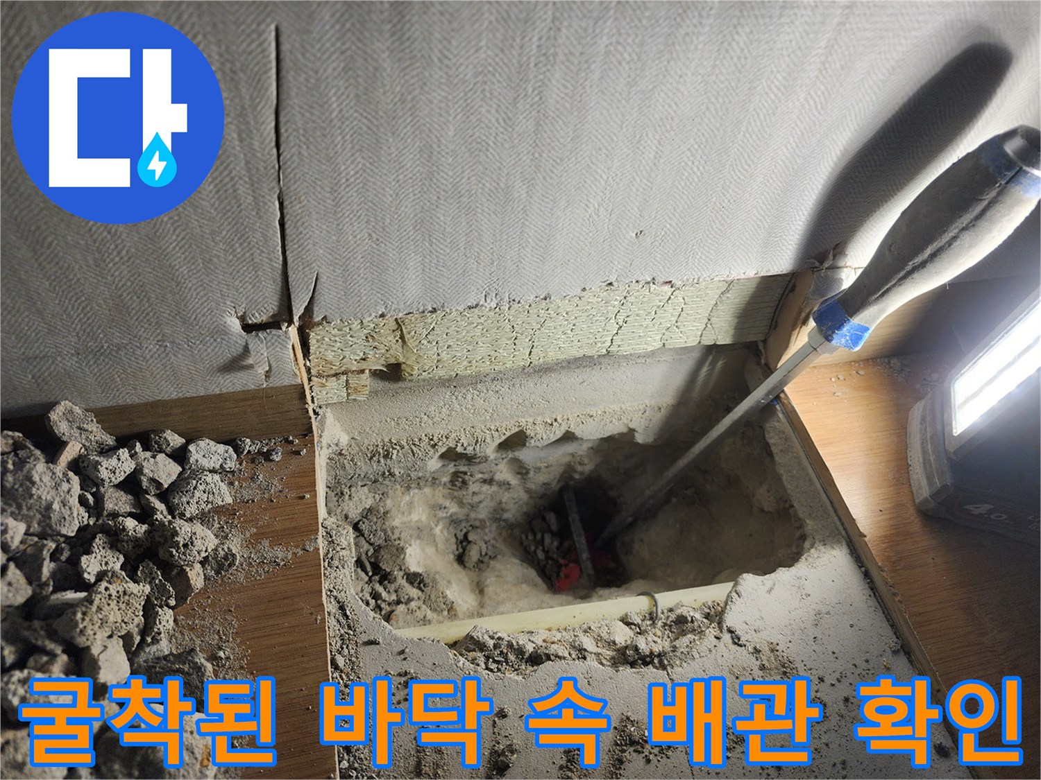 바닥 파쇄 후 노출된 배관을 점검하는 장면