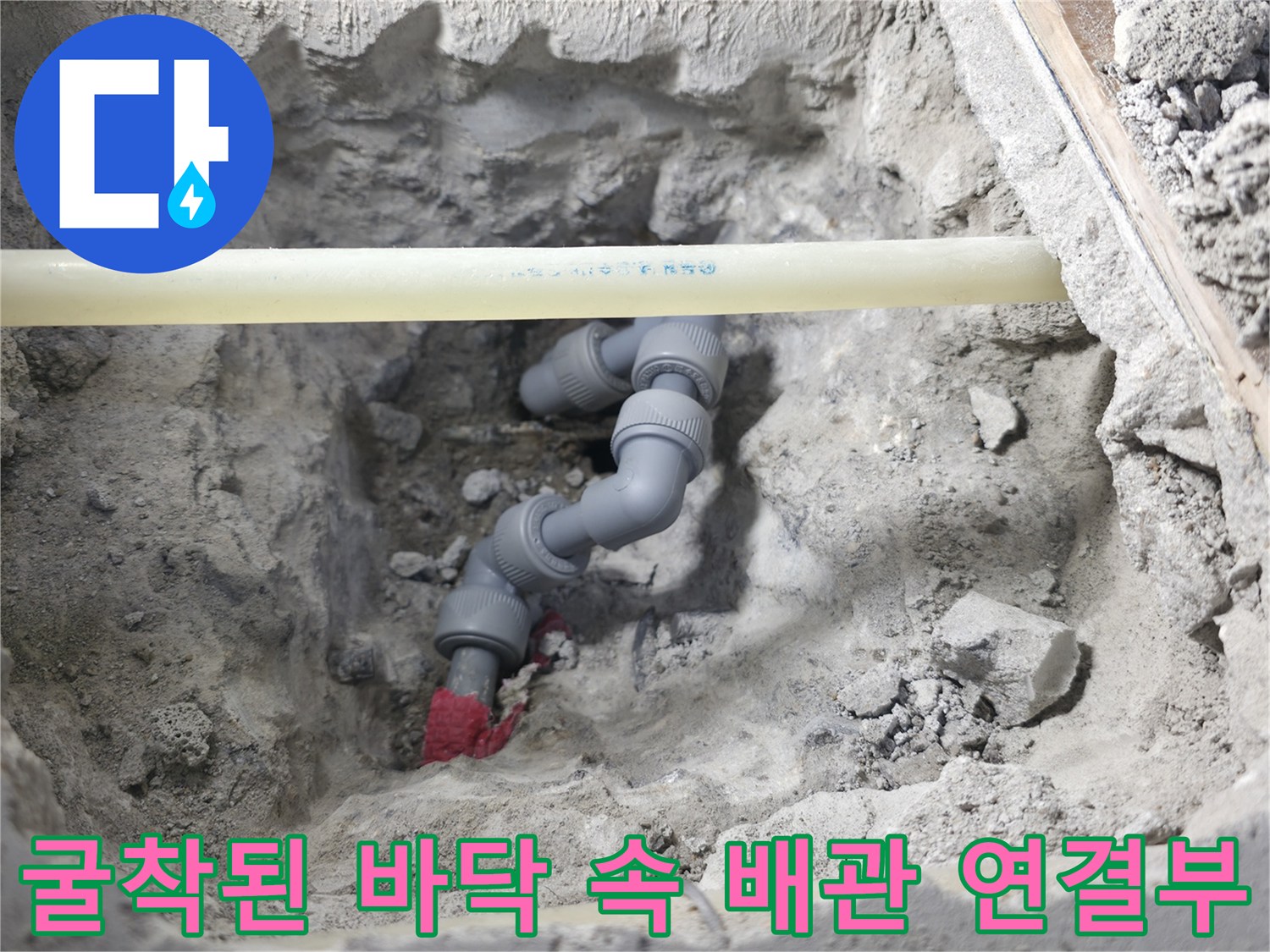 파쇄된 콘크리트 사이로 드러난 회색 PVC 파이프