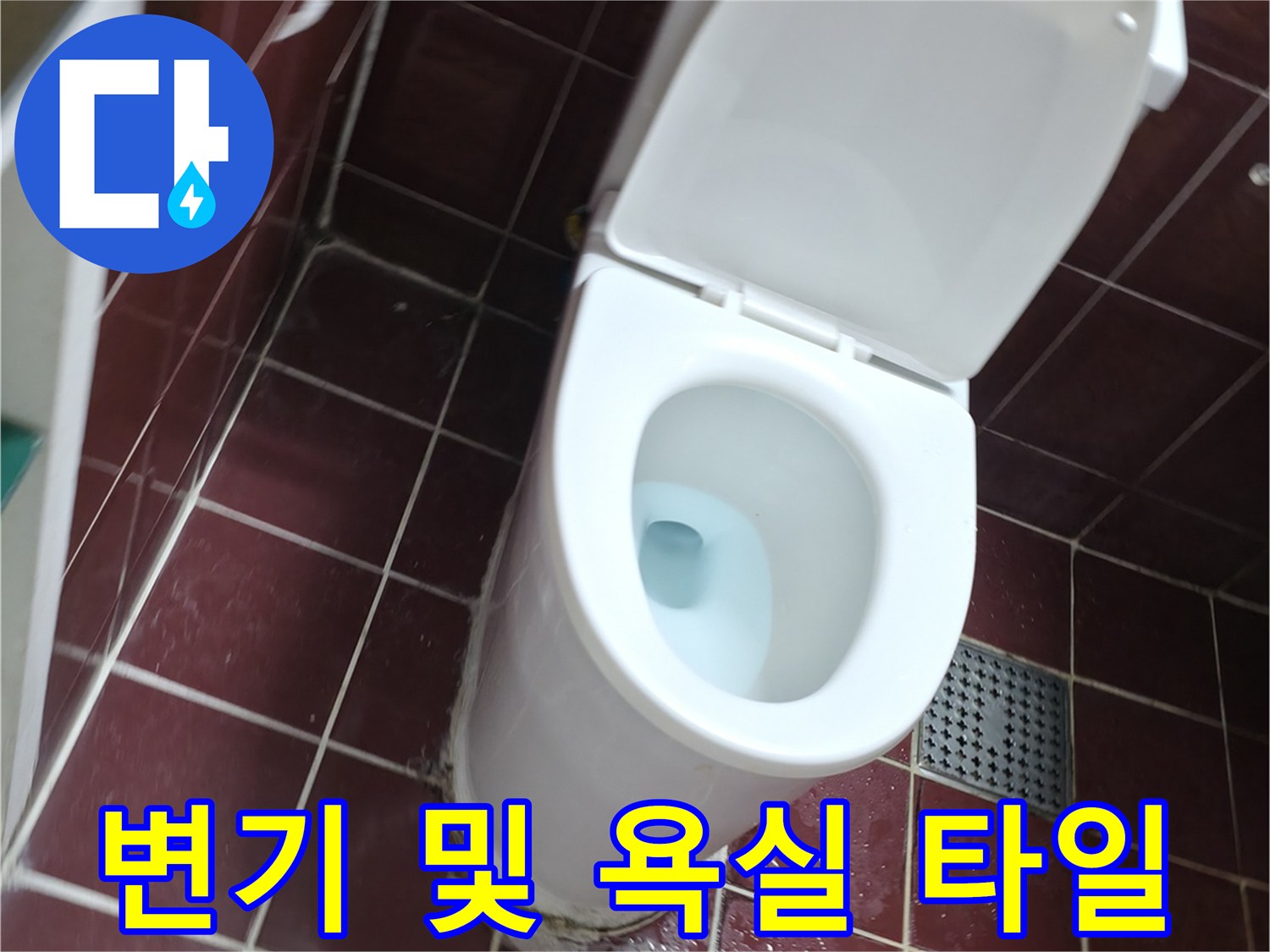 변기와 붉은색 계열의 욕실 타일 모습