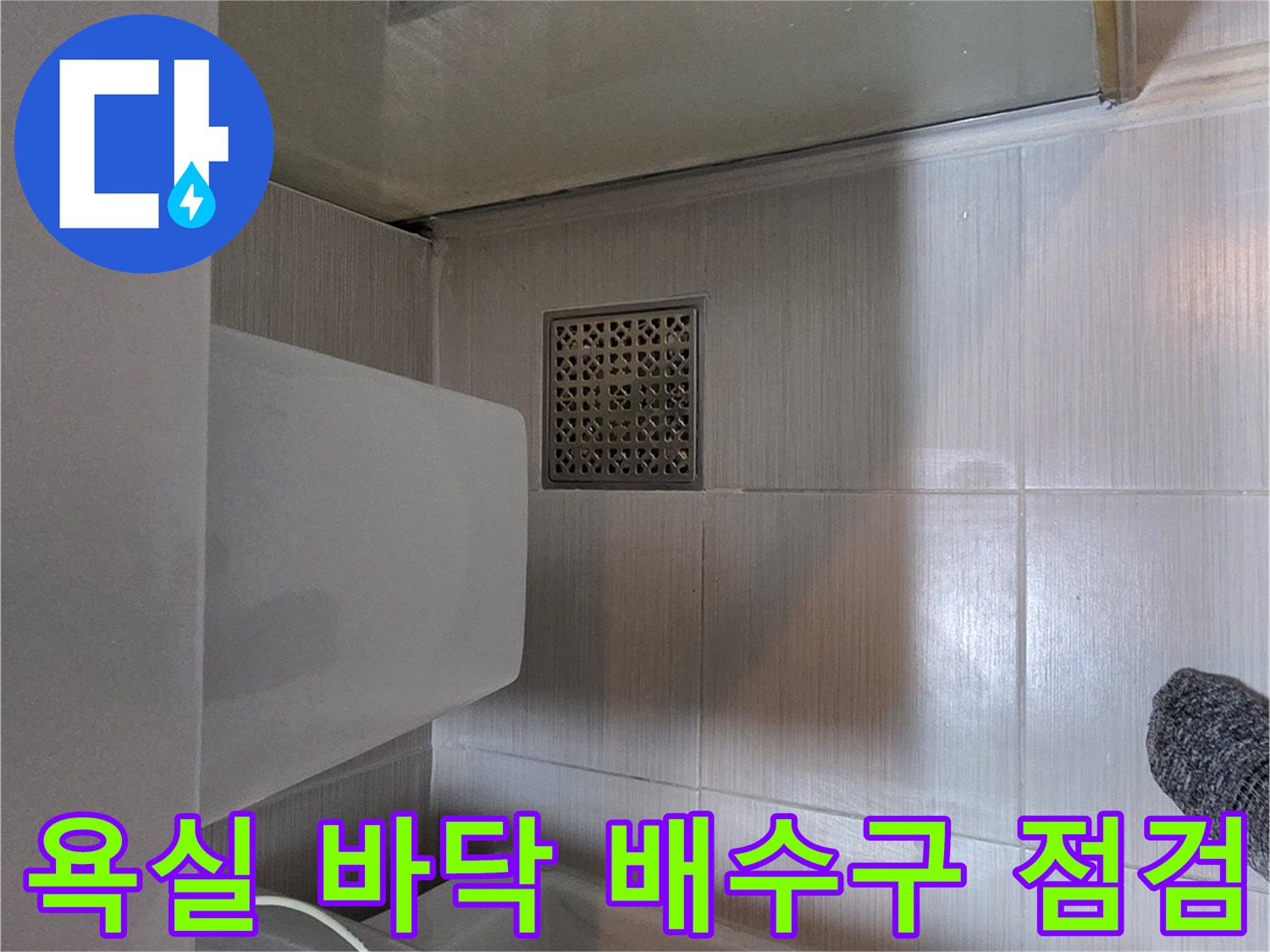 변기 옆 화장실 배수구와 타일 마감 사진