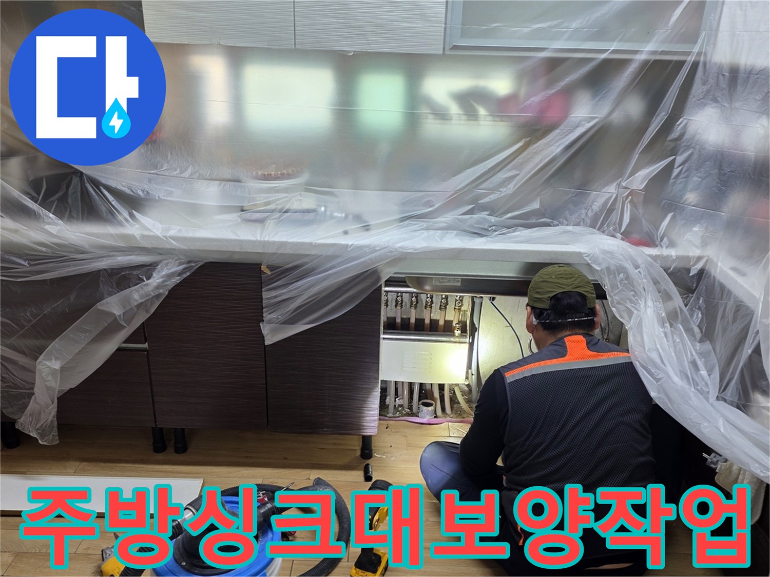 비닐로 감싸진 싱크대 하단 내부 점검 모습