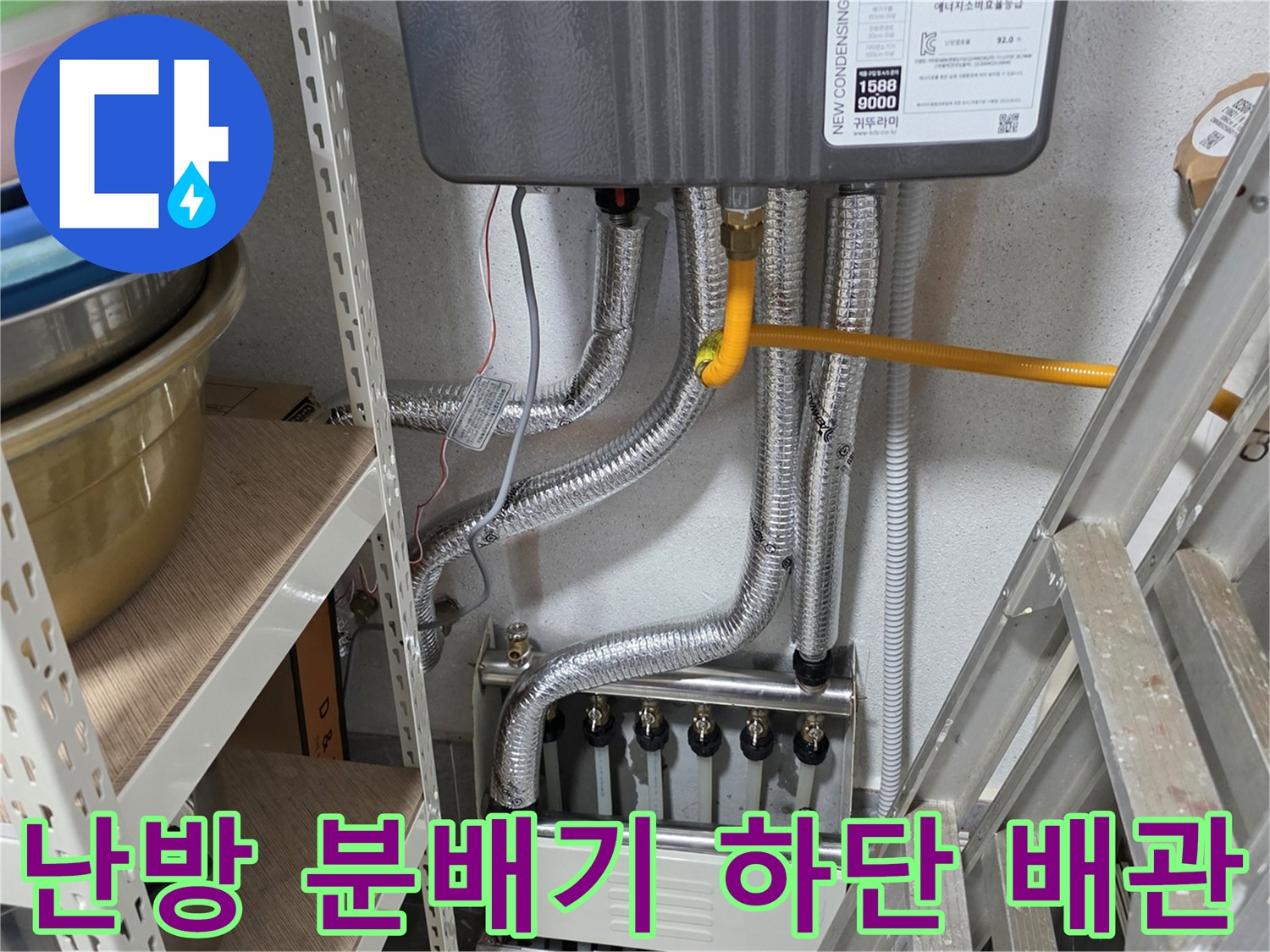 보일러 하부의 은색 보온재 덮인 배관과 분배기