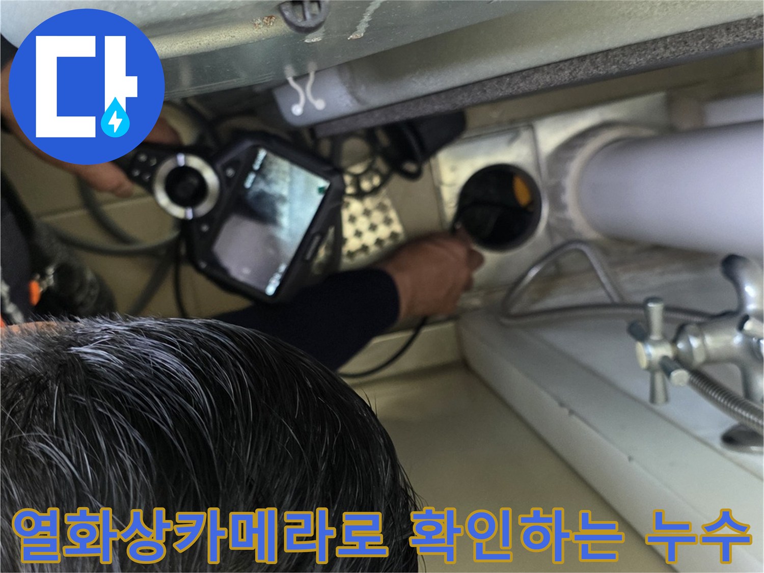 누수 진단을 위해 열화상 카메라를 사용하여 배관 주변을 점검하는 모습