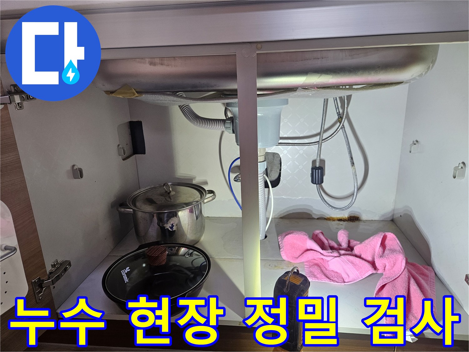 누수-전문가가-싱크대-하부장의-물기-흔적을-정밀하게-검사하는-모습을-담은-이미지입니다