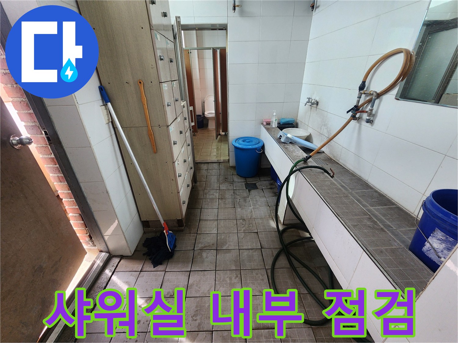 샤워실 타일 벽면과 연결된 급수 호스 모습