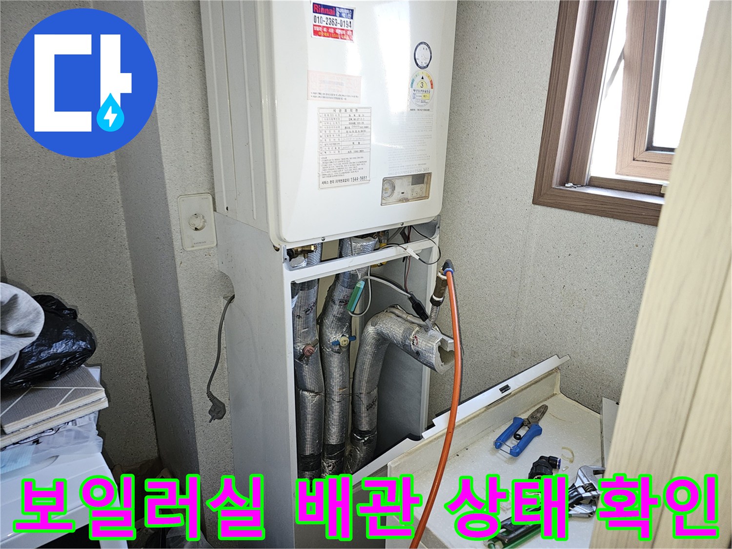 보일러-하단부-노출된-배관-및-수리자재