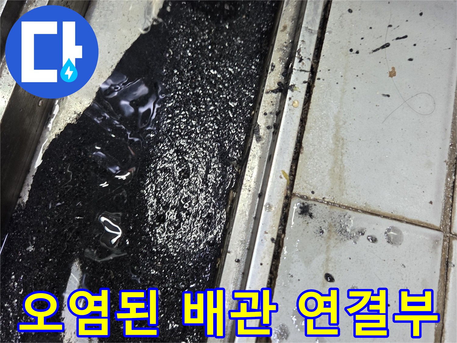 검은색 오염물로 덮인 하수 배관 주변 바닥 상태