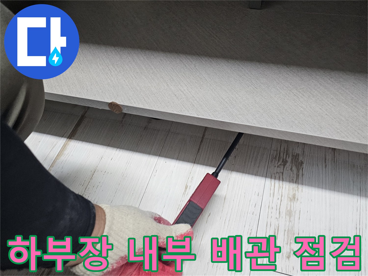 싱크대 하단 공간-배관 연결 부위를 조사하는 장면