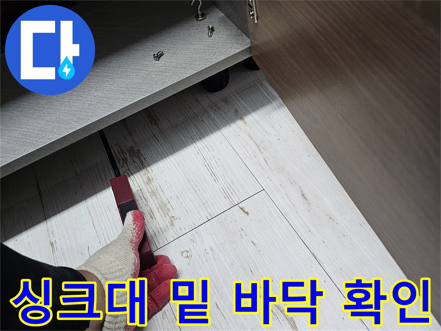 작업자가-장갑을-끼고-싱크대-하부장-바닥을-살피는-사진