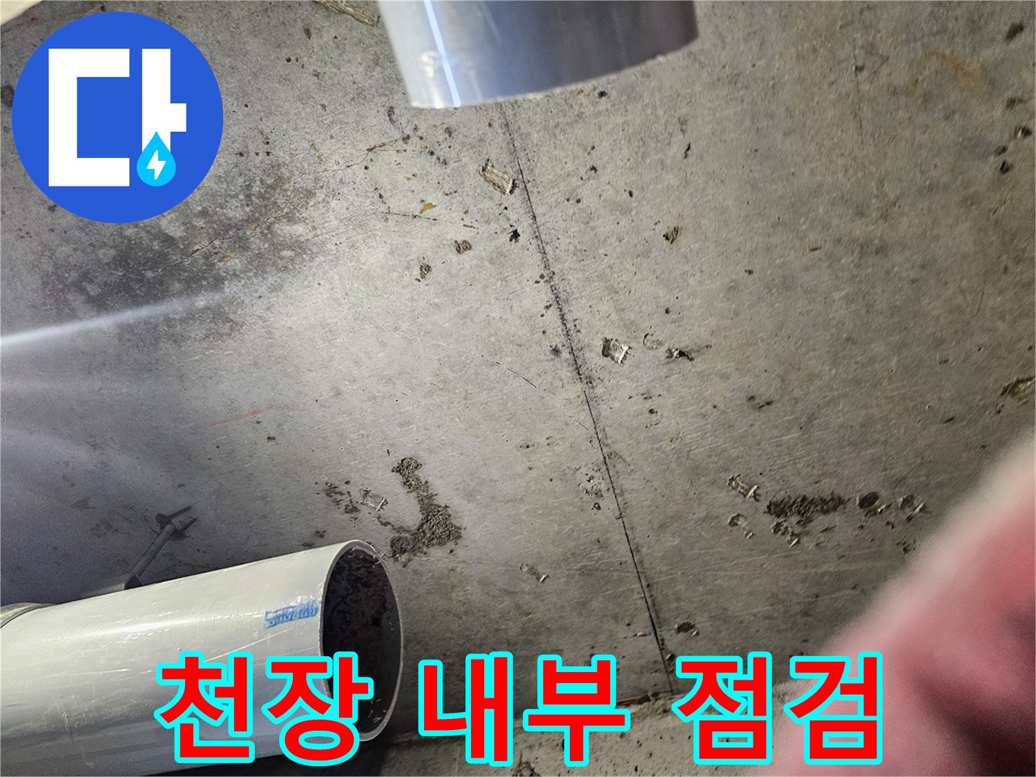 절개된 천장 안쪽의 젖은 콘크리트와 배관 구조