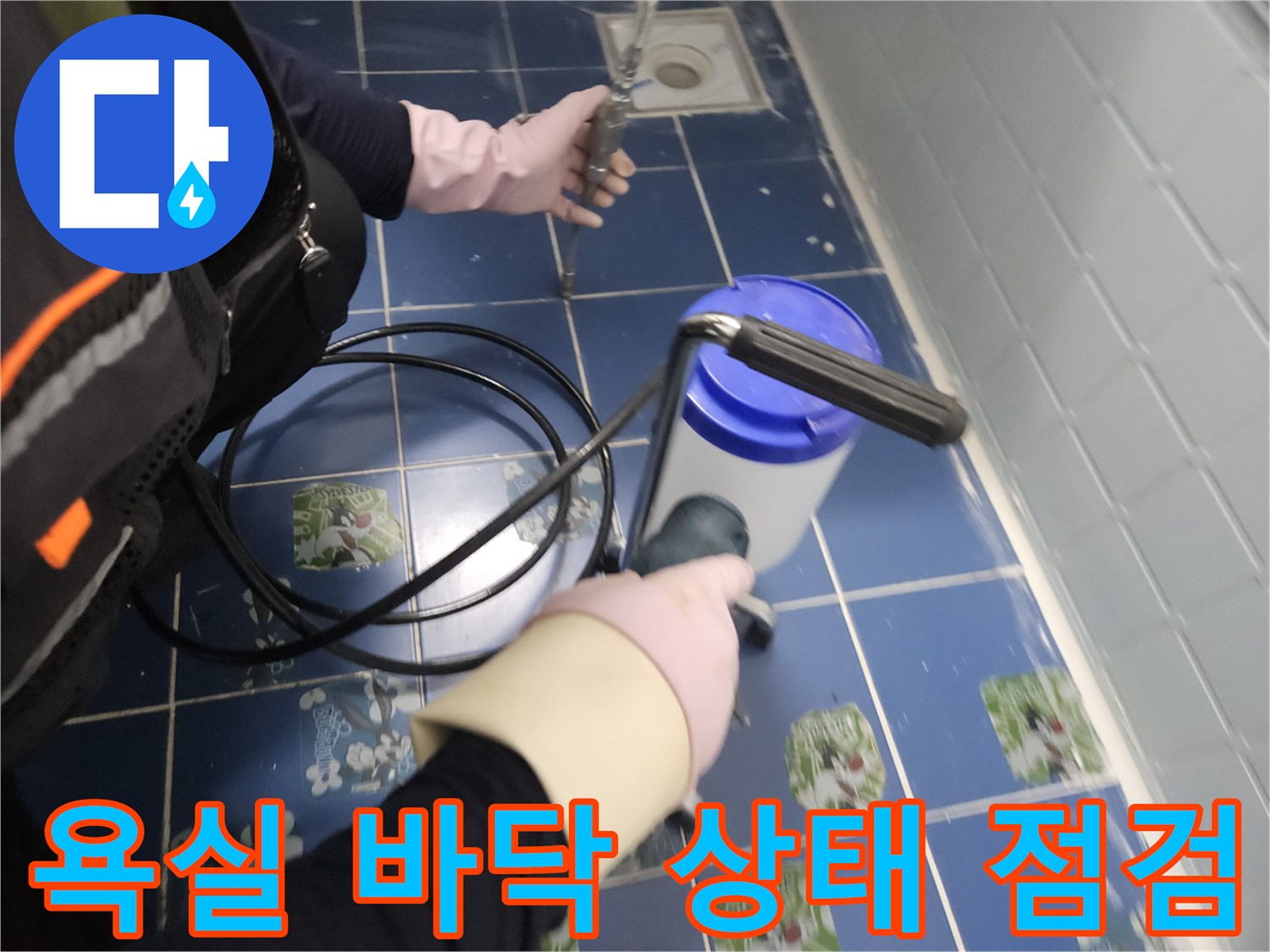 파란 타일 사이의 균열을 확인하는 작업자의 모습