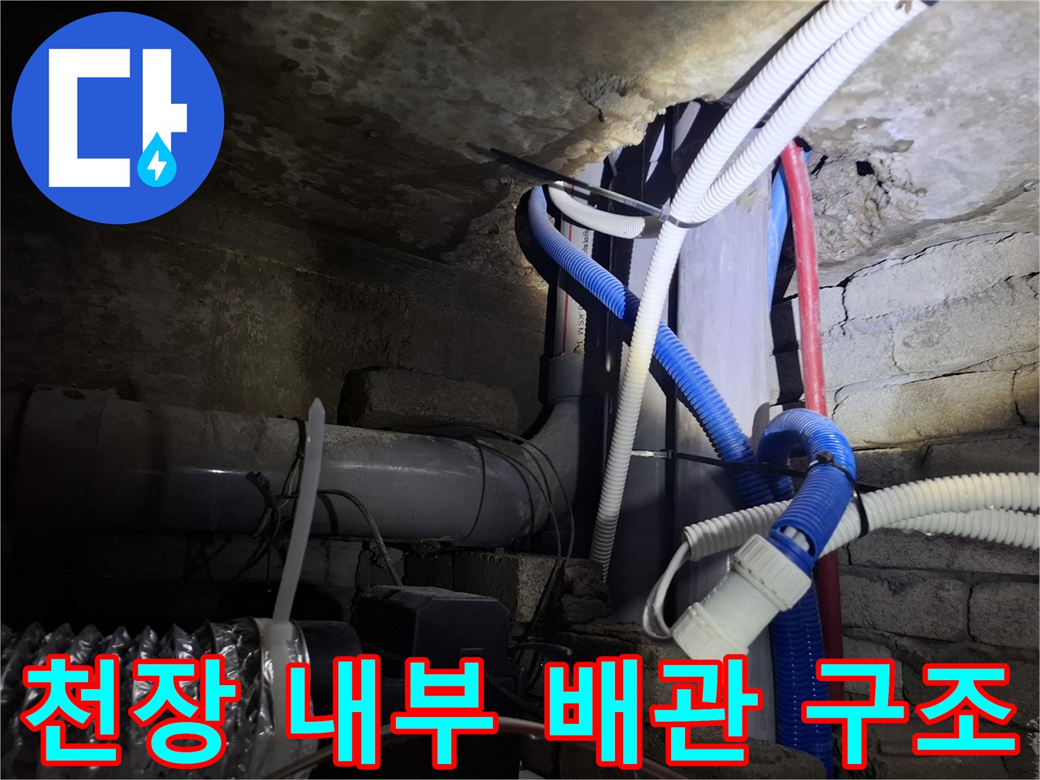 벽돌 구조물과 연결된 천장 배관 및 호스들