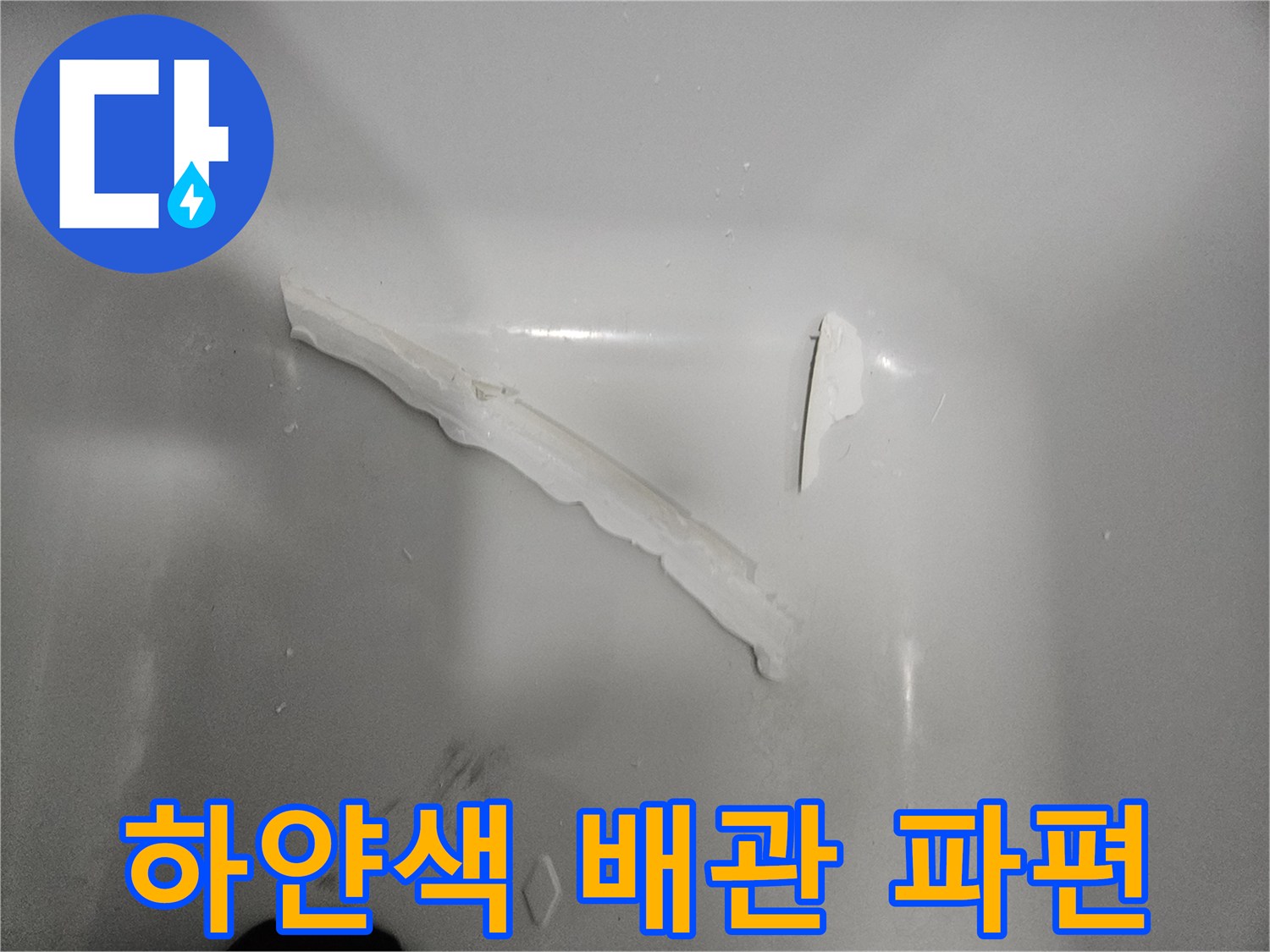 욕실 바닥에 떨어진 하얀색 배관 부속 조각