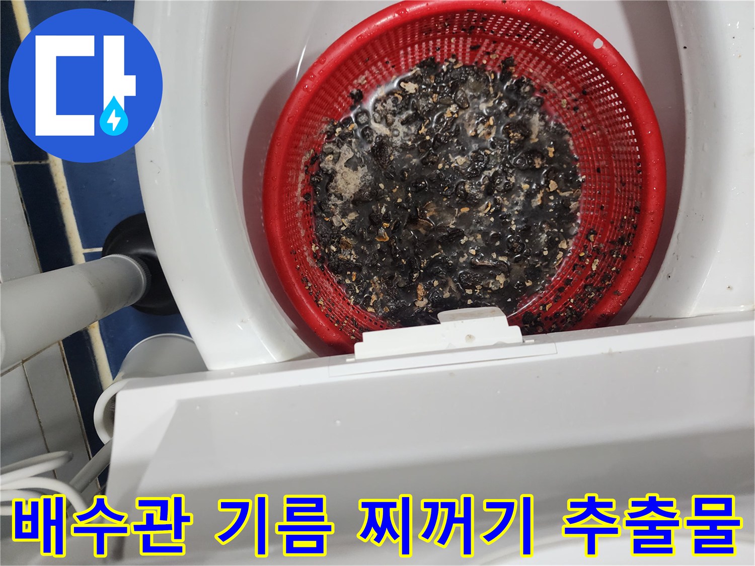 빨간색 채반에 모인 검은색 배수관 기름 슬러지 덩어리