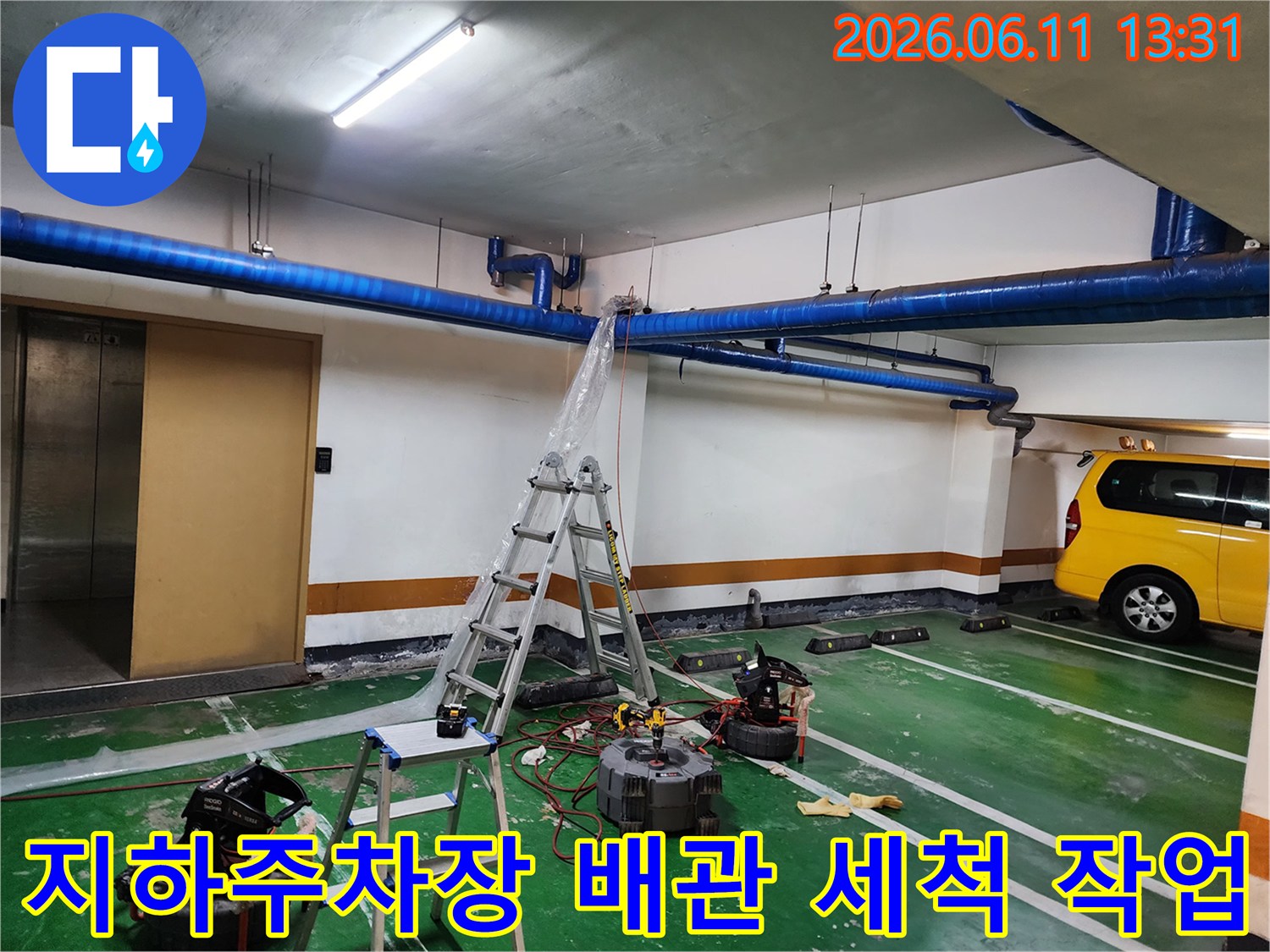 지하주차장 천장 배관 작업을 위해 설치된 사다리와 고압 세척 장비