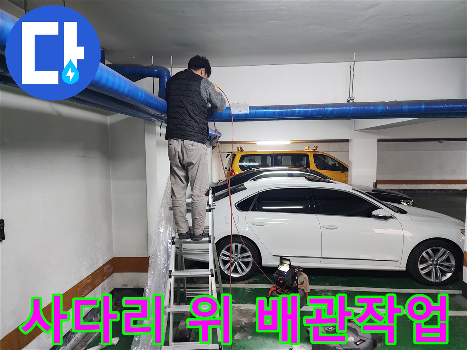 지하주차장 천장 파란색 배관을 점검하는 작업자