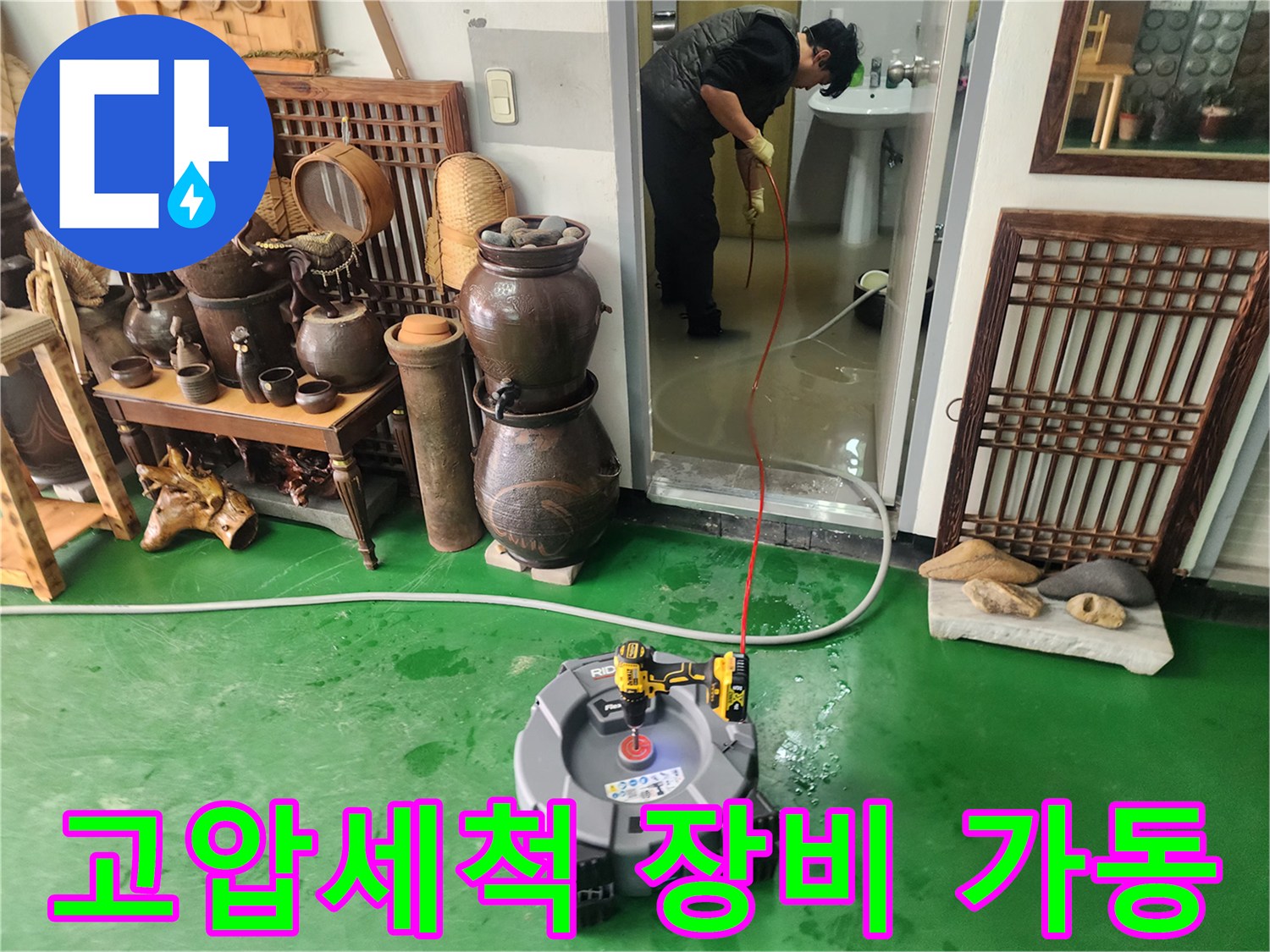 초록색 바닥에서 작동 중인 고압 세척기 장비
