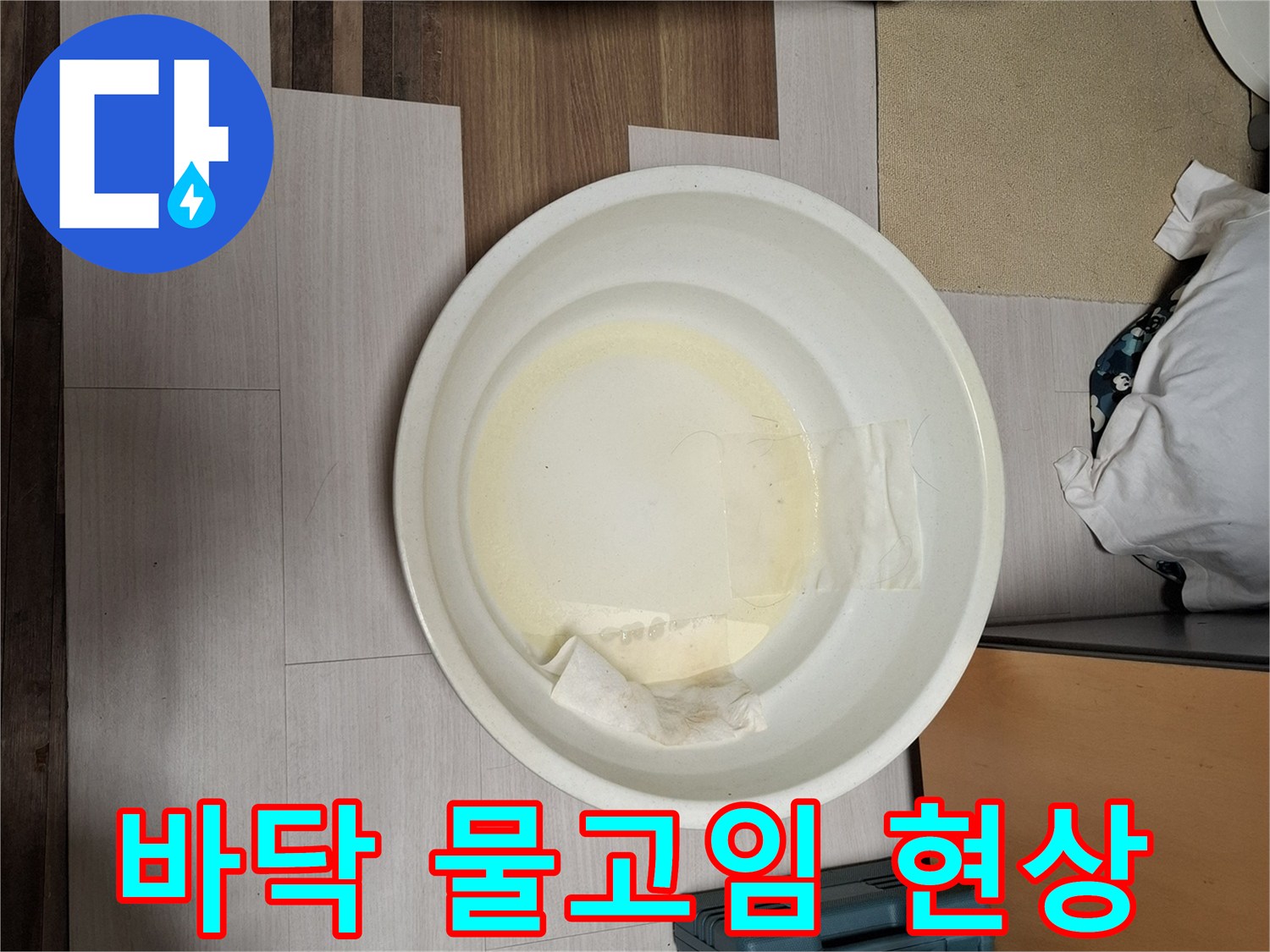 거실 바닥재 위에 고여 있는 물과 수건