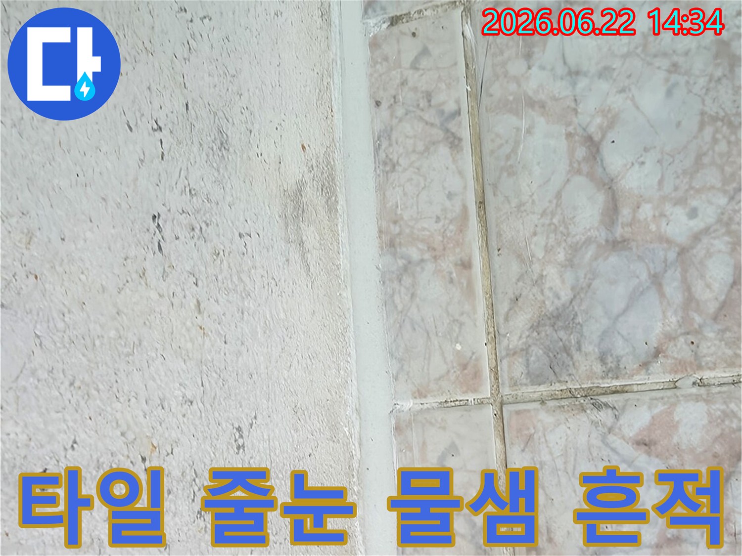 누수가-의심되는-벽면-하단부와-타일-경계면을-근접-촬영한-이미지입니다