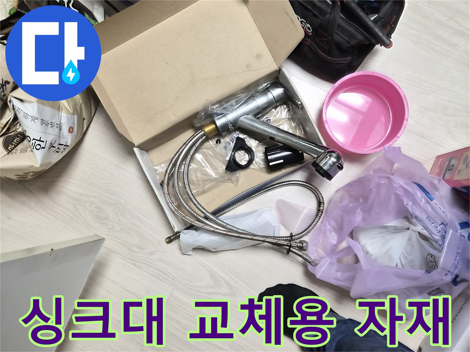 바닥에 놓인 새 싱크대 수전과 작업 도구들