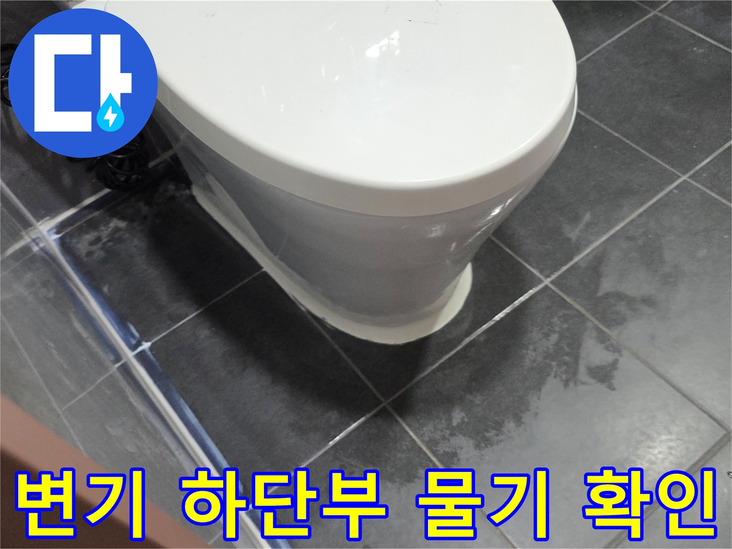변기 아래쪽 타일의 젖은 흔적