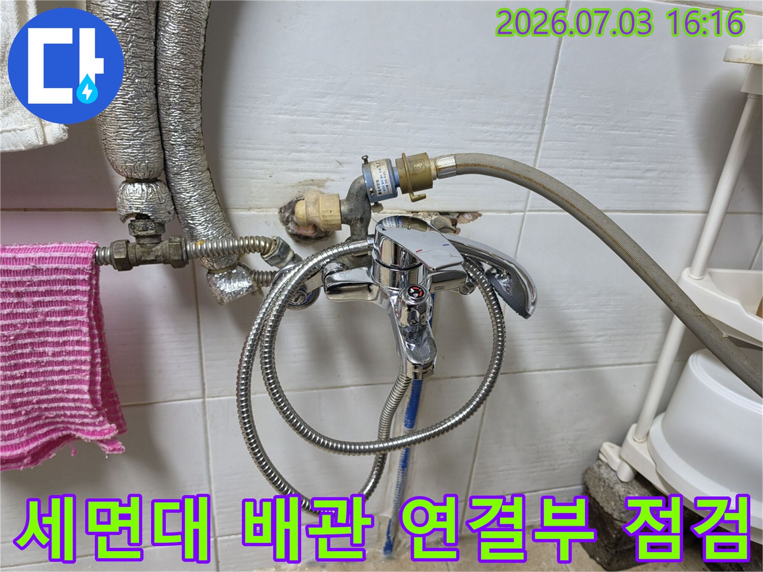 세면대 하단 배관과 호스가 연결된 모습