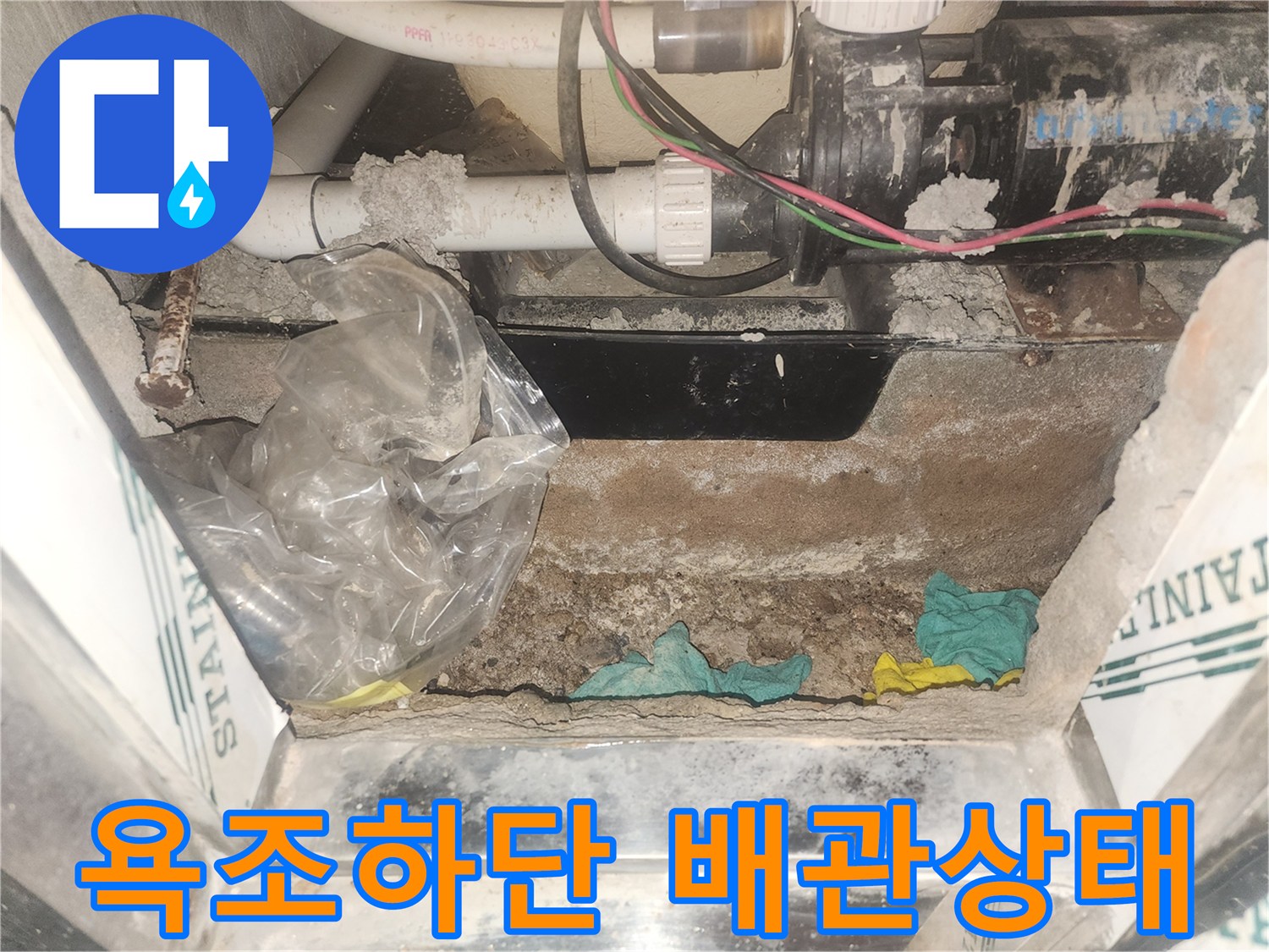 월풀 욕조 하단부의 배관과 습기 찬 바닥 모습