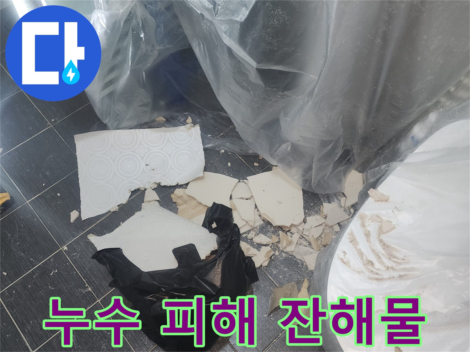 바닥 타일 위에 떨어진 천장 파편과 비닐