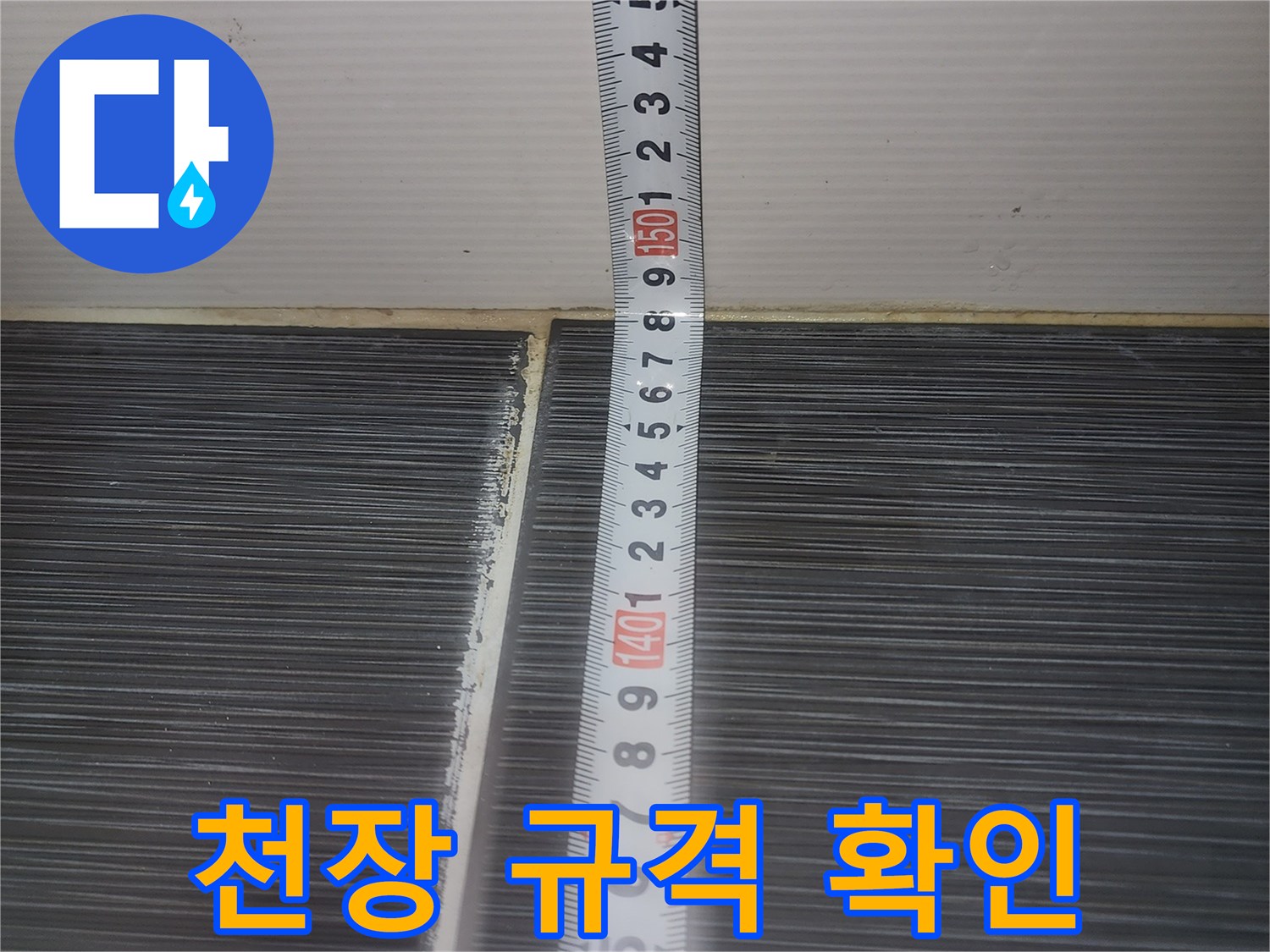 줄자로-천장 마감재의 길이를 재는 작업 장면